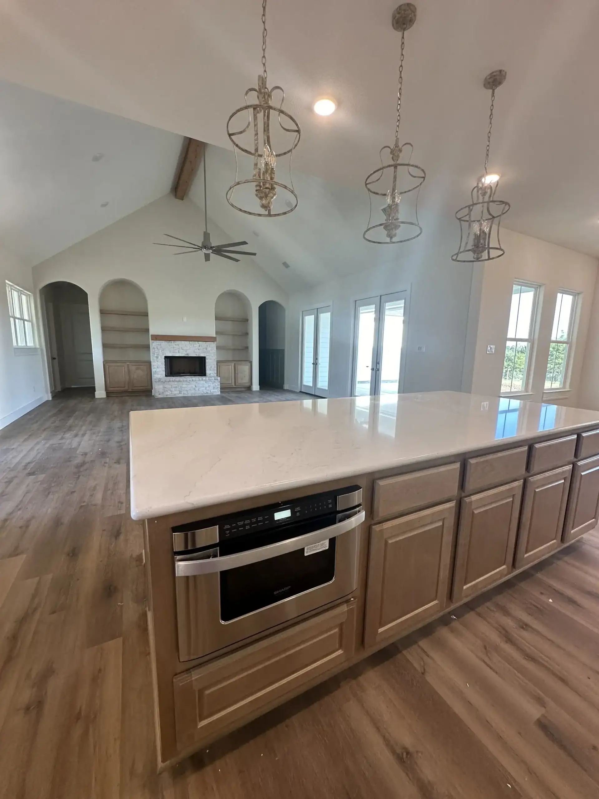 Custom home great room with a vaulted ceiling, arched doorways and built-in cabinetry