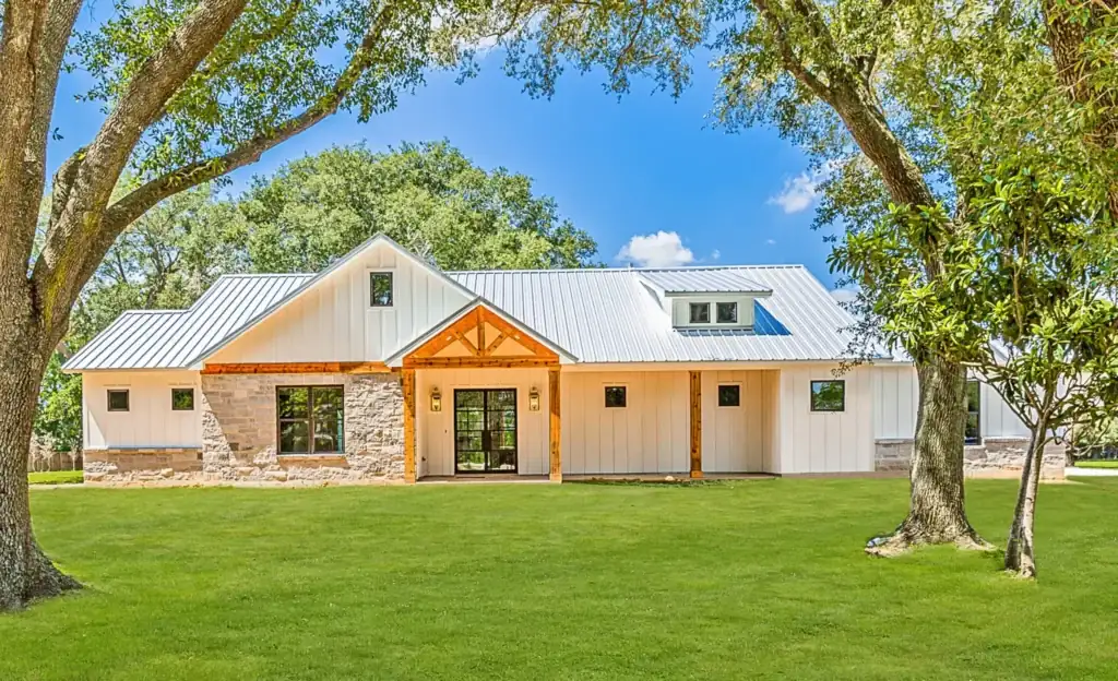 Custom modern farmhouse with wood-and-stone entry columns and board-and-batten siding