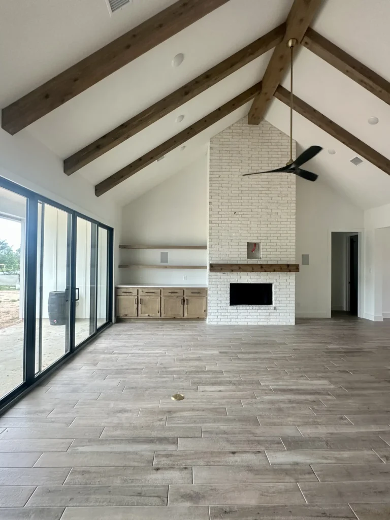 Custom home great room with a stone fireplace, vaulted ceiling and sliding glass doors