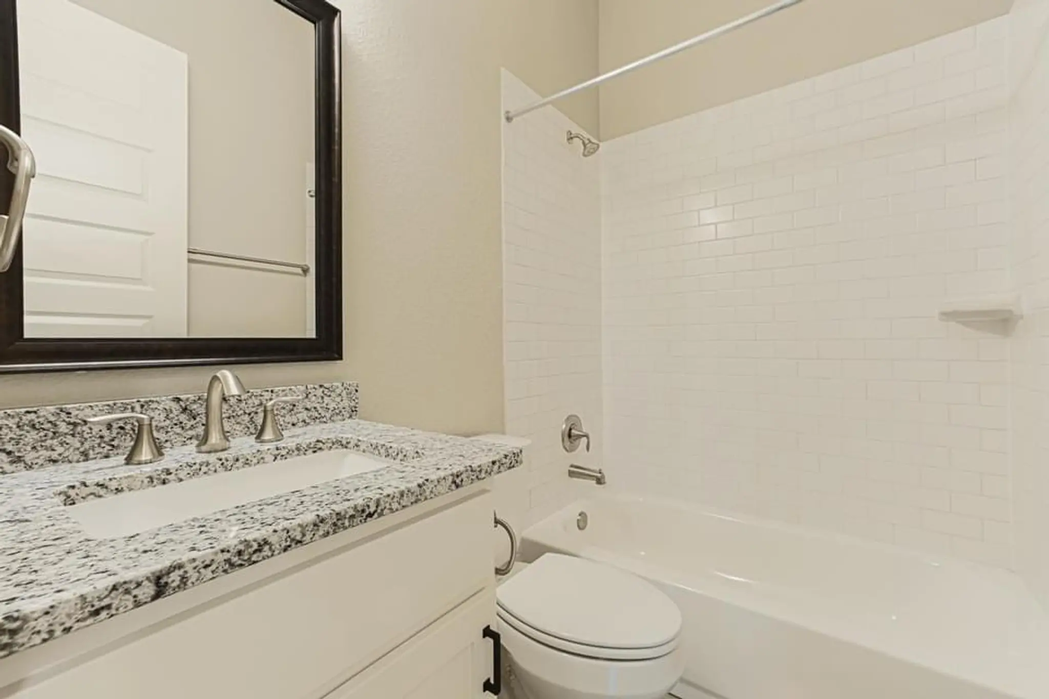 Custom home guest bathroom with a tub-shower combo, granite vanity and toilet