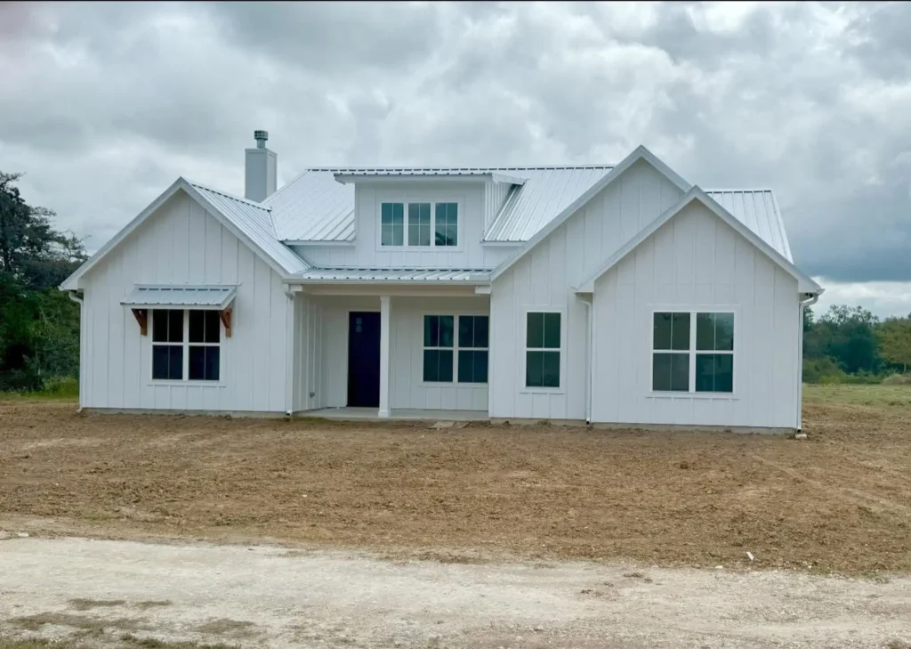 Newly built white modern farmhouse custom home with dark-framed windows and gables