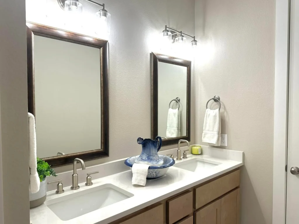 Custom home bathroom with a double vanity, wood cabinets and two framed mirrors