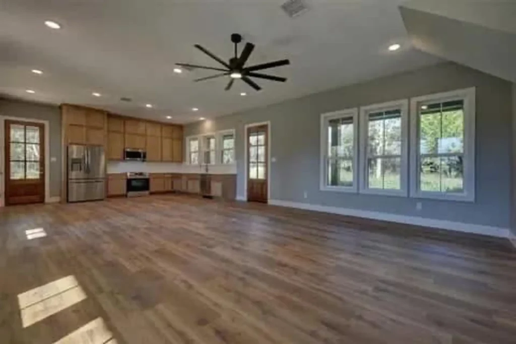 Open-concept custom home living area with an adjoining kitchen and wood flooring