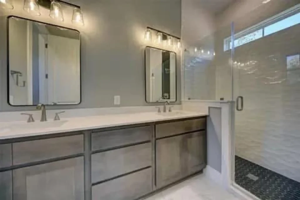 Custom home master bathroom with a double vanity, framed mirrors and a glass shower