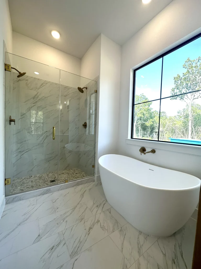 Custom home master bathroom with a glass-enclosed shower and a freestanding soaking tub