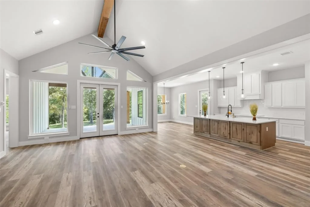 Custom home great room with a vaulted wood-beam ceiling open to the kitchen