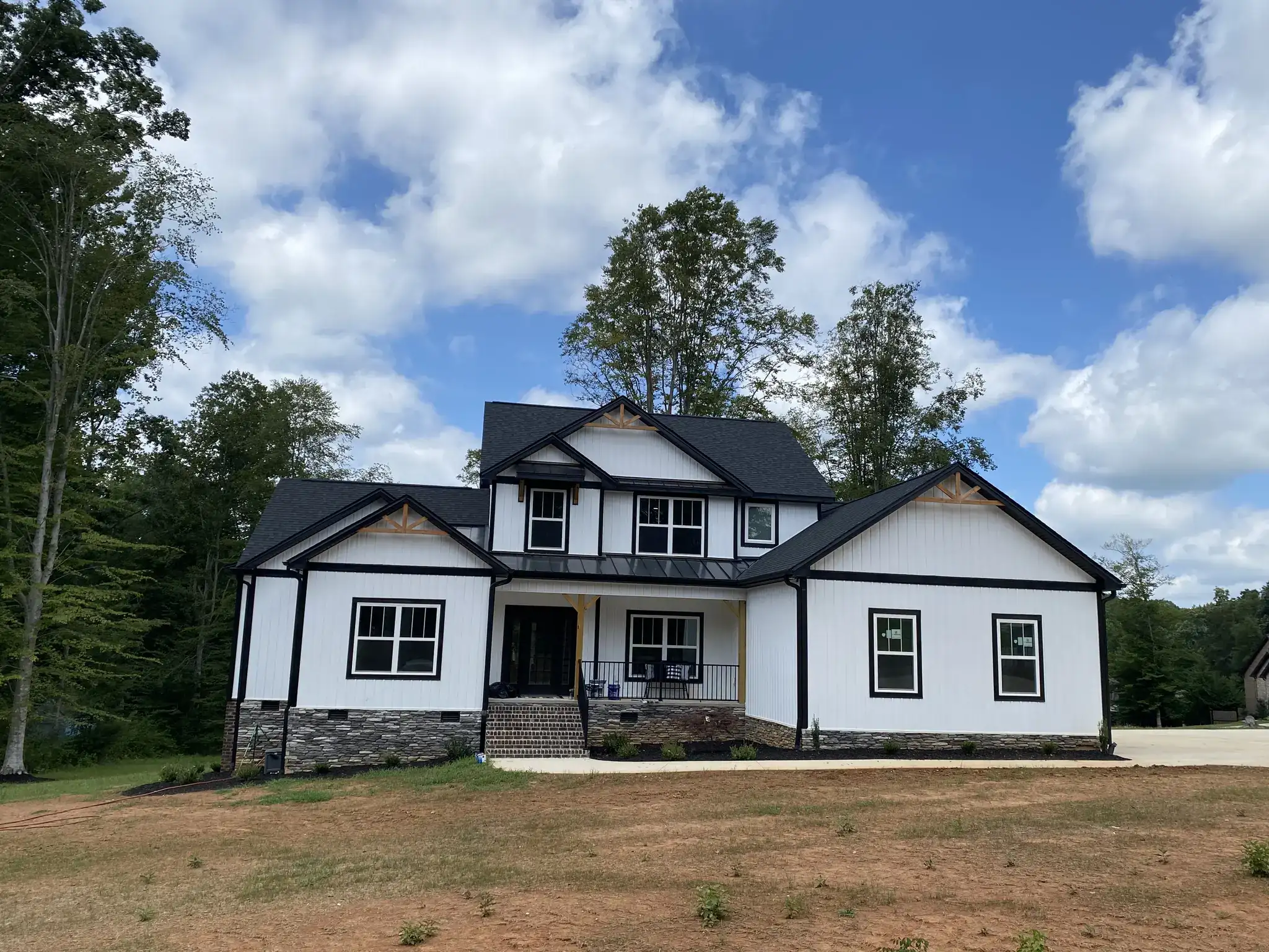 Newly built white two-story modern farmhouse custom home with a dark shingle roof